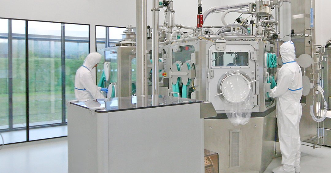 Two operators in a pharmaceutical manufacturing area using equipment