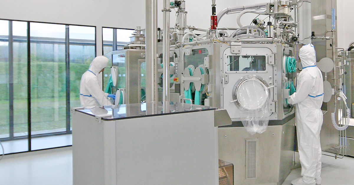 Two operators in a pharmaceutical manufacturing area using equipment