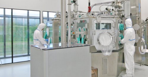 Two operators in a pharmaceutical manufacturing area using equipment