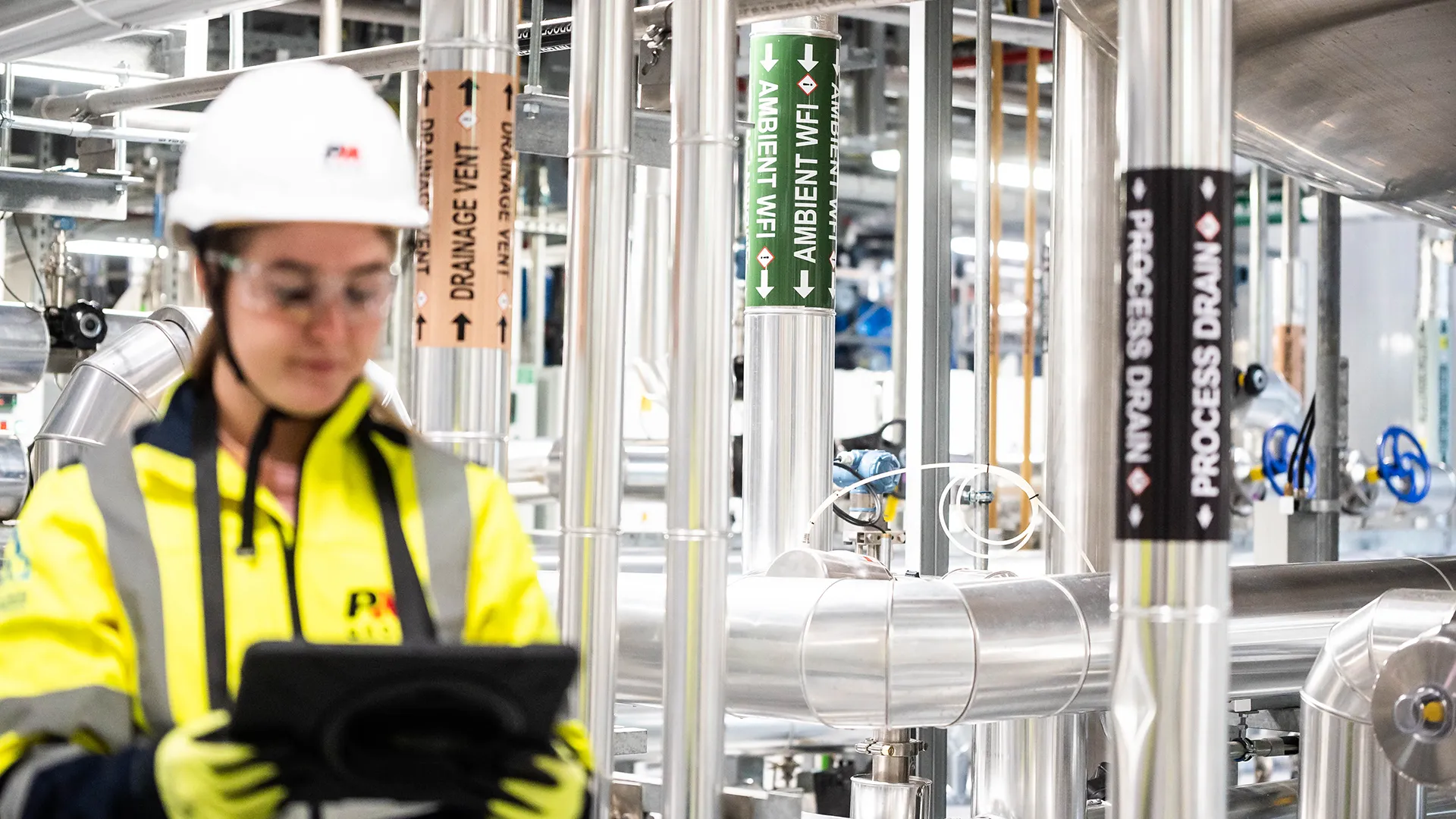 Engineer with tablet in pharma manufacturing plant